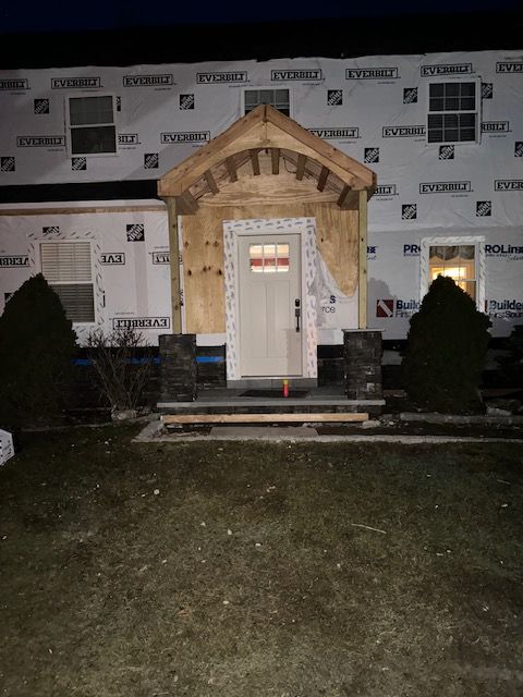 The front door of a house is being built at night.