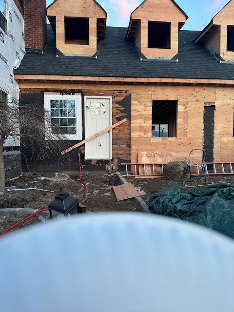 A house under construction with a ladder in front of it.