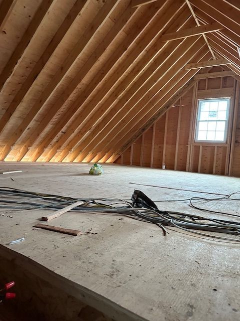 There is a window in the attic of a house under construction.