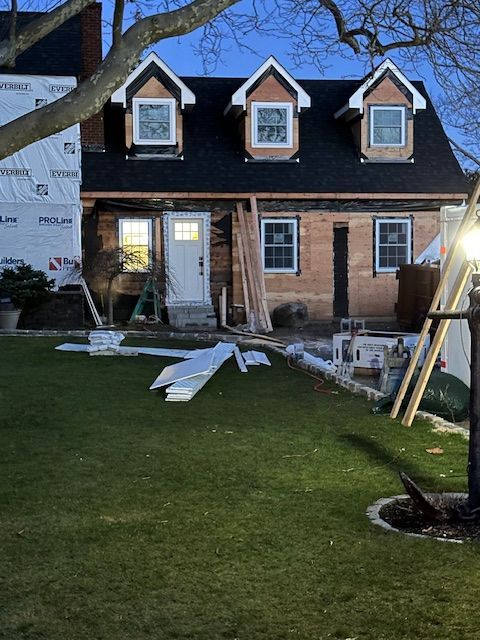 A house with a black roof is being remodeled.