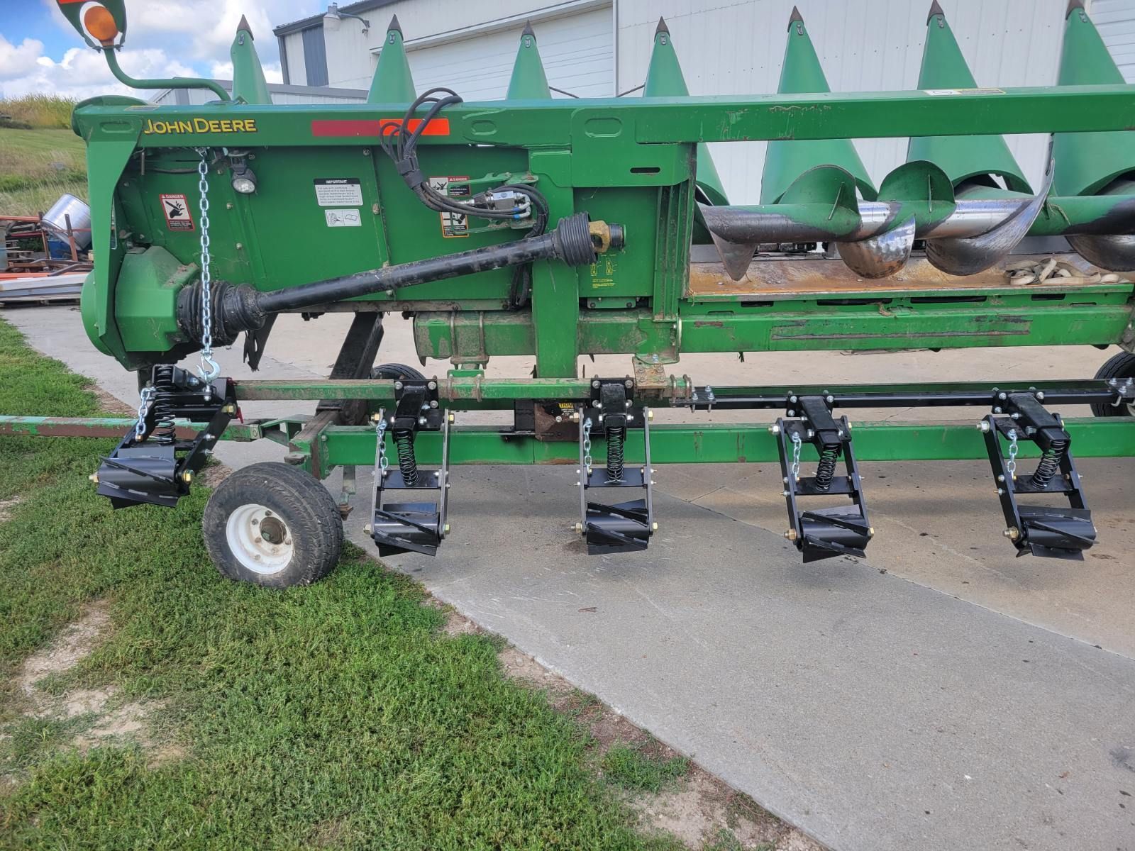 A green tractor is parked on the side of the road.