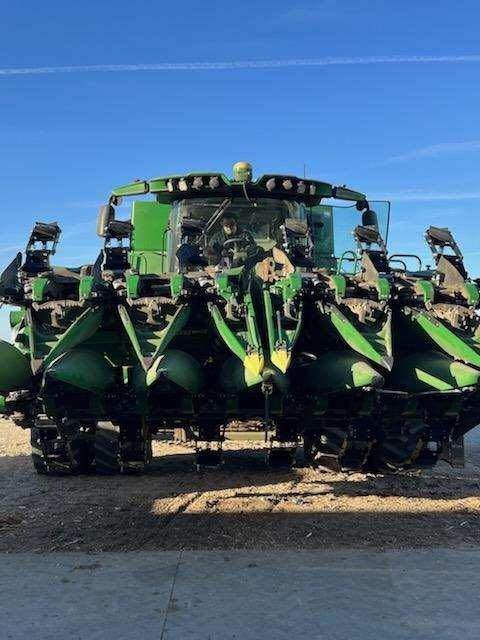 A green tractor is parked on the side of the road