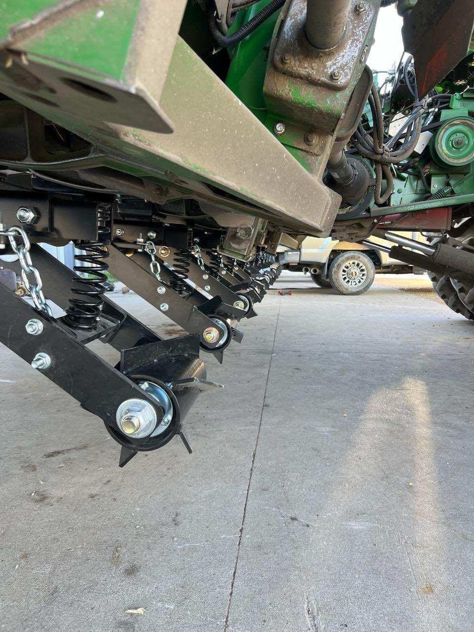 A green tractor is parked on the side of the road.