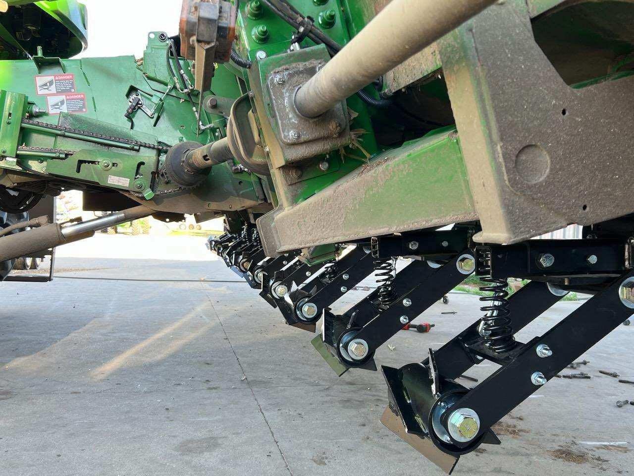 A green tractor is parked in a parking lot.