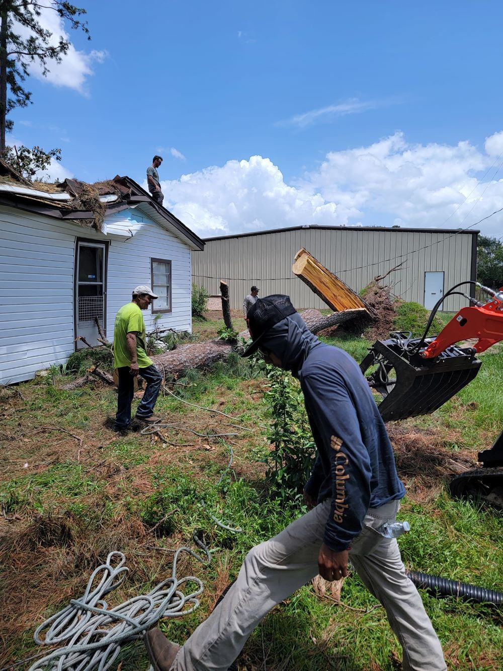 Two men are working on the roof of a house.