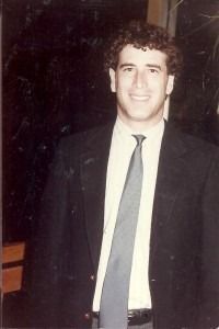 A man in a suit and tie is sitting at a conference table.