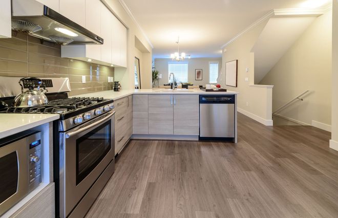 Modern kitchen with stainless steel appliances, large island, and pendant lights