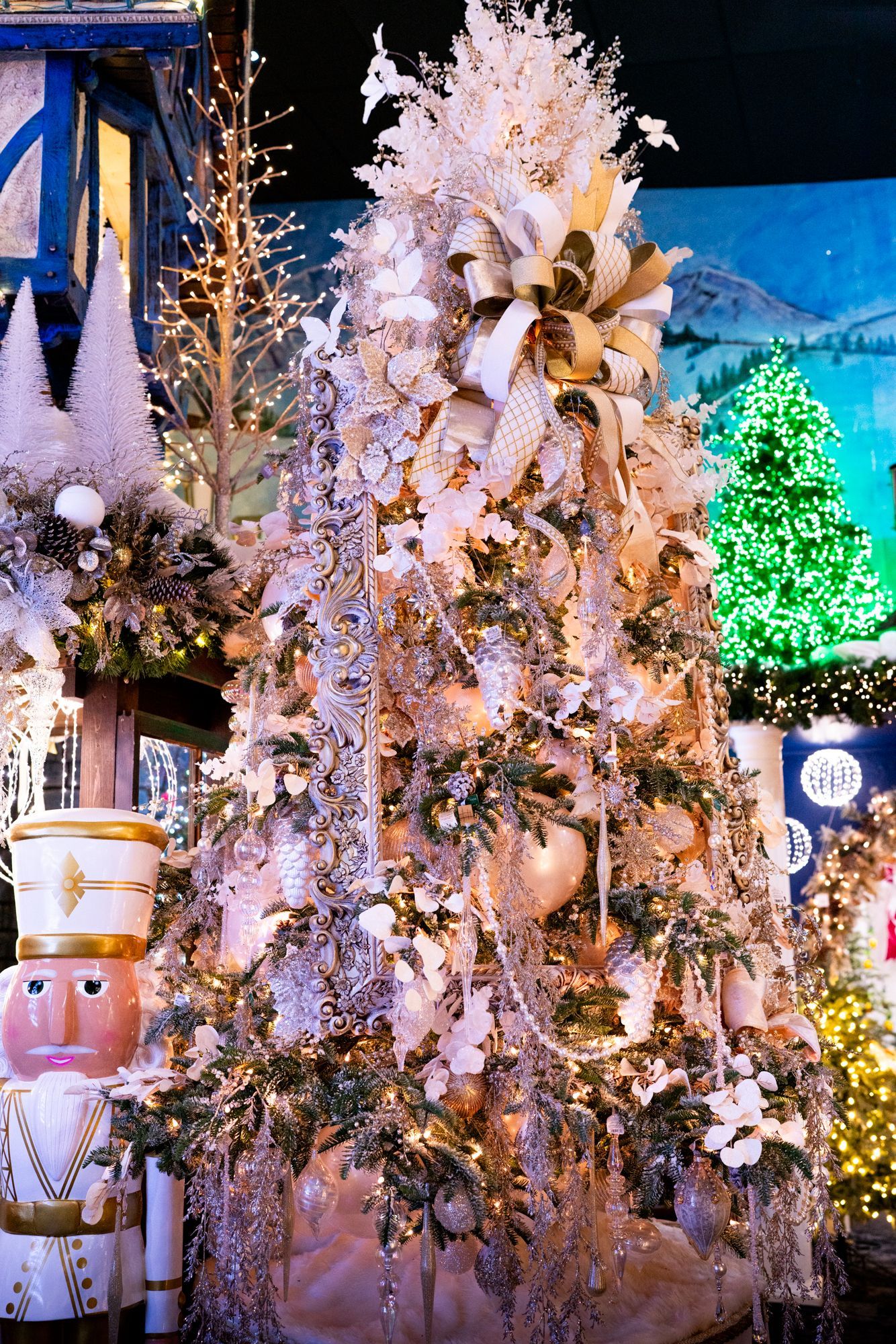 A fully decorated Christmas tree in ivory and champagne stands 12 feet tall.
