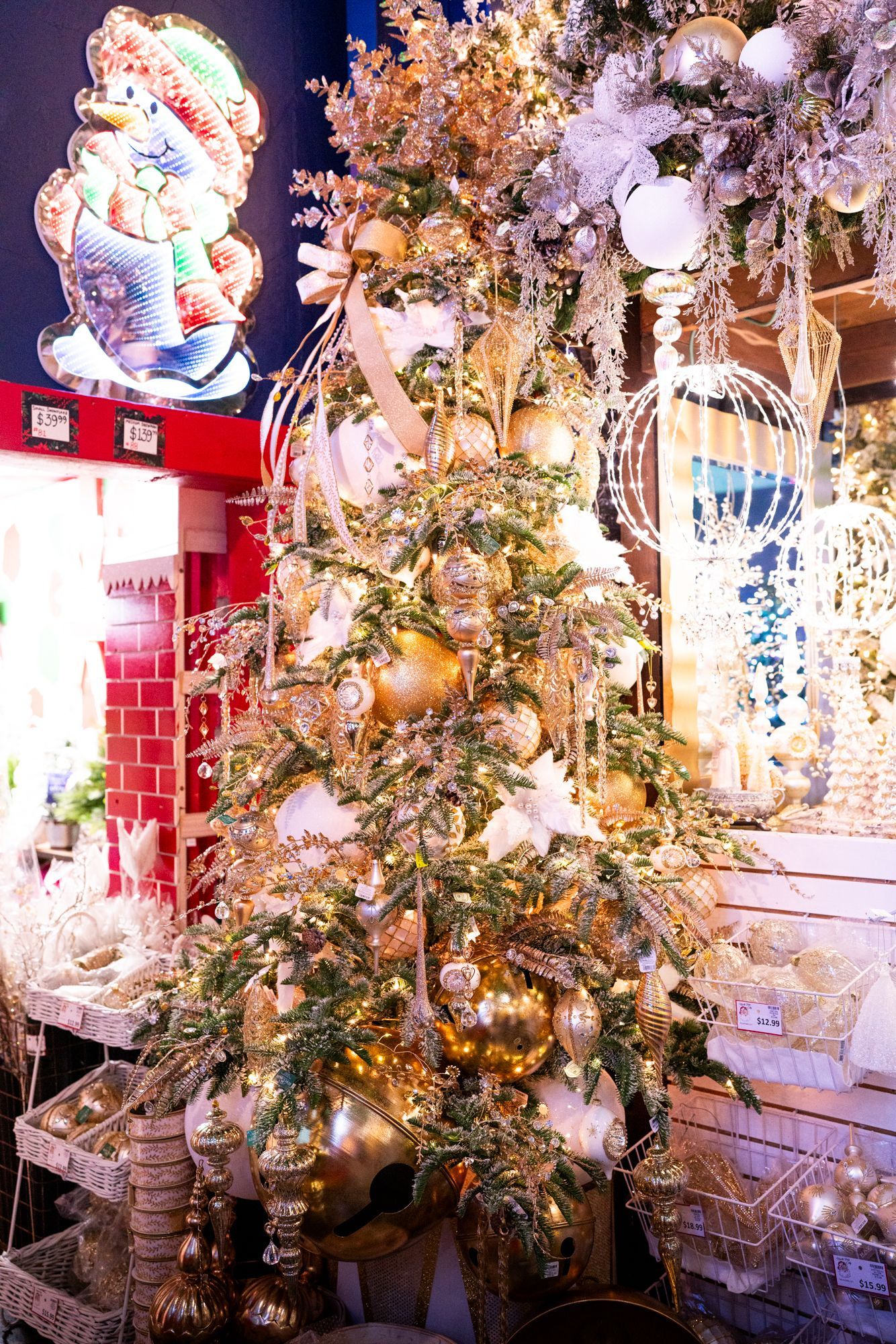 A fully decorated Christmas tree in gold and white stands eight feet tall.
