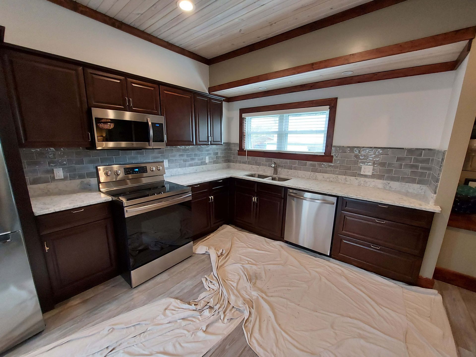 A kitchen with stainless steel appliances and wooden cabinets.