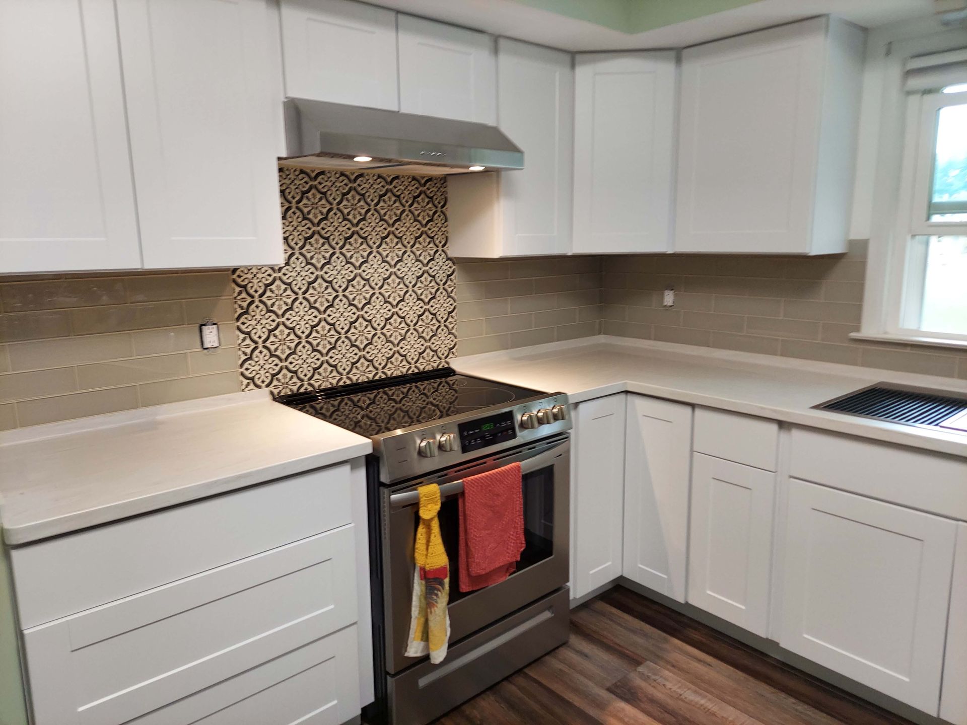 A kitchen with white cabinets and stainless steel appliances.