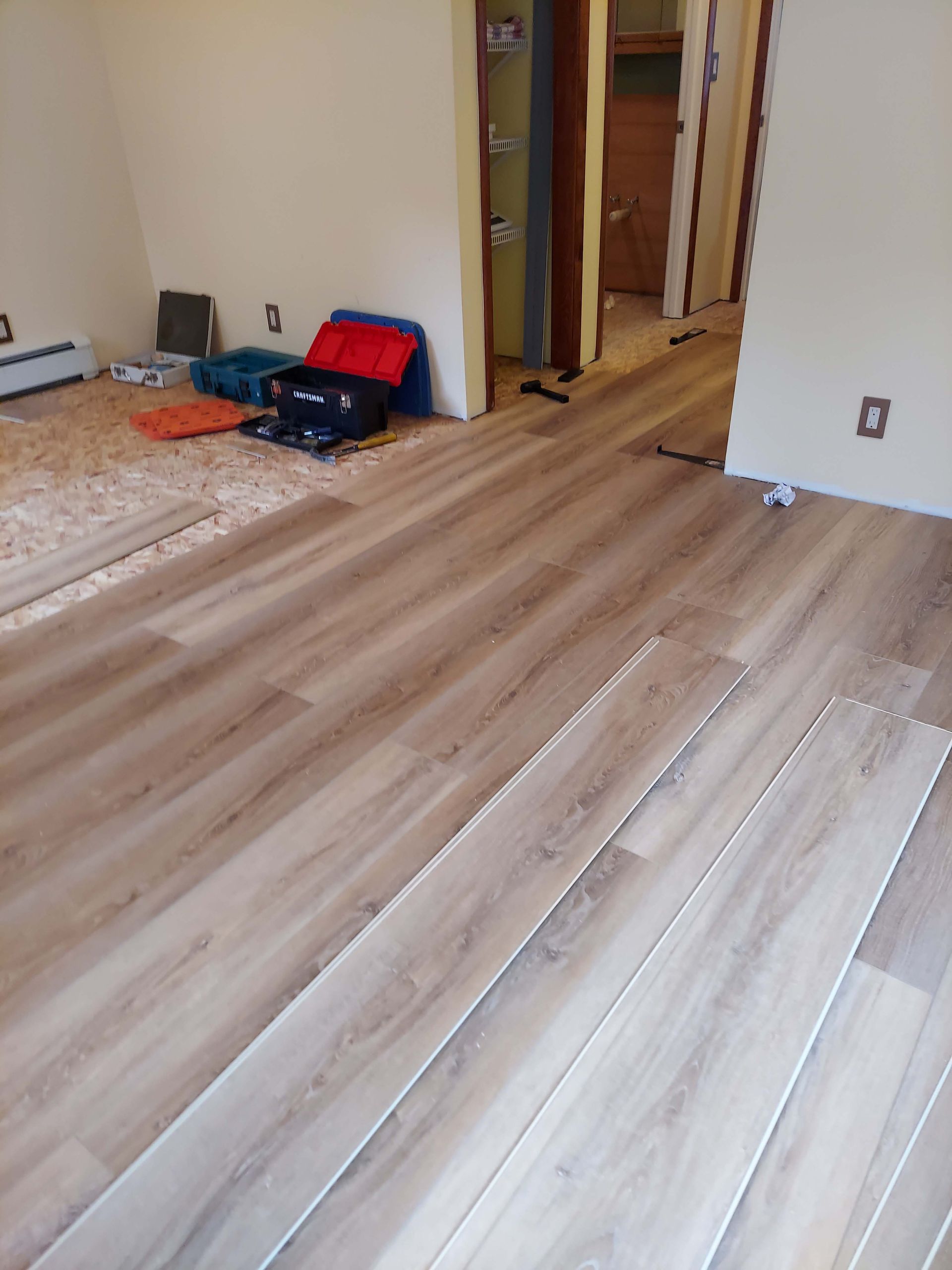 A room with a wooden floor and a suitcase on the floor.