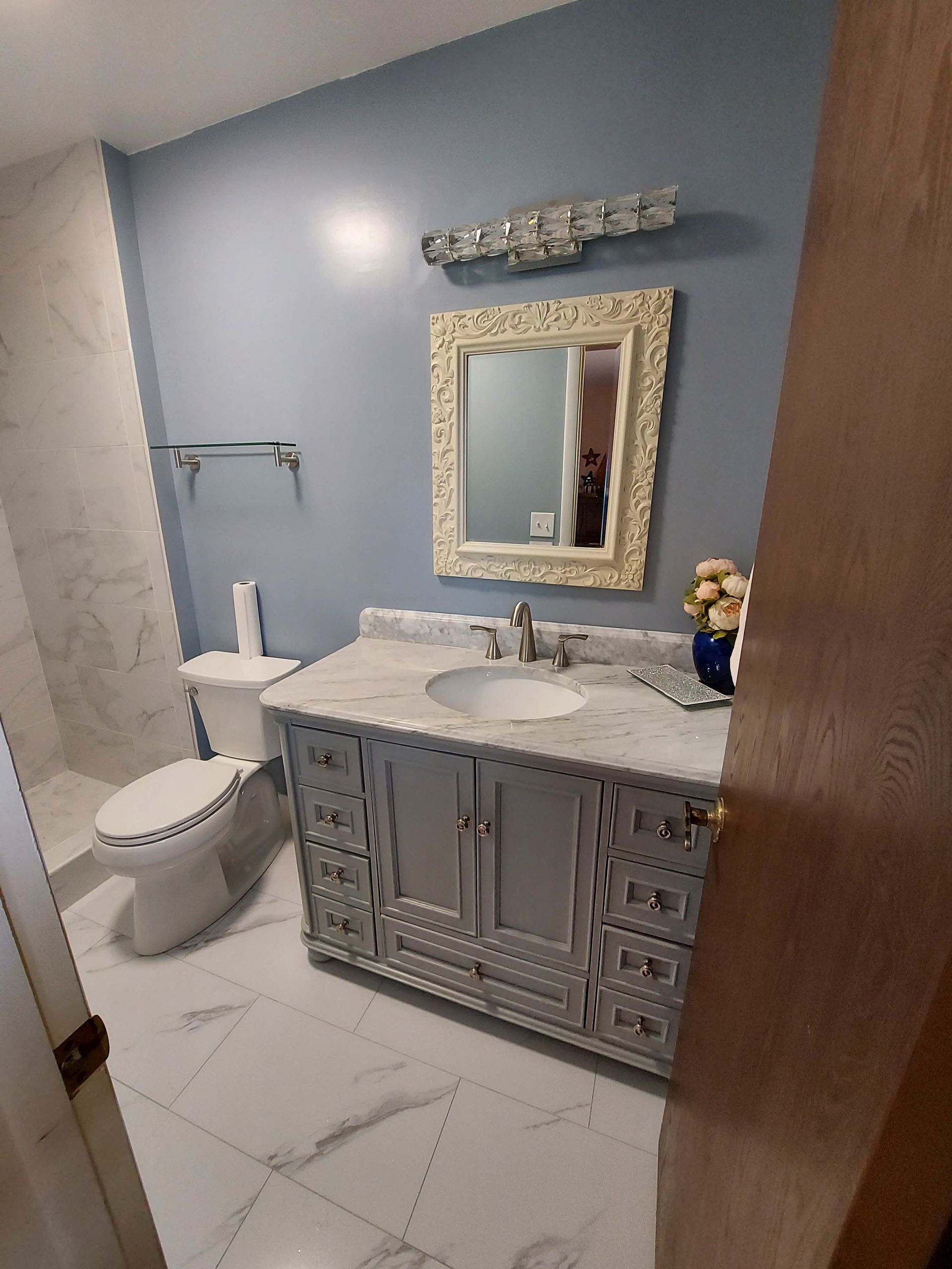 A bathroom with a sink , toilet and mirror.