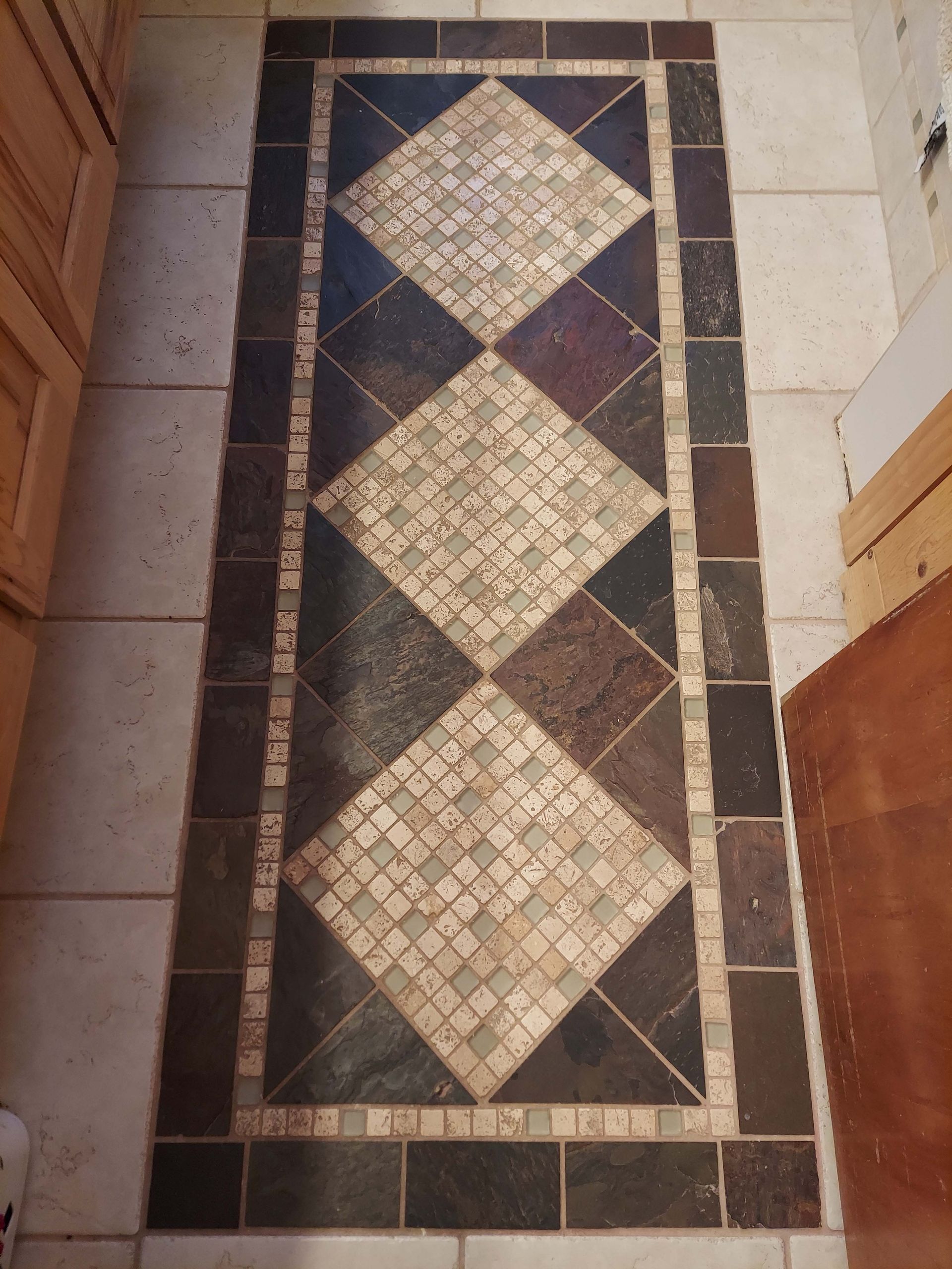 A mosaic tile floor with a diamond pattern