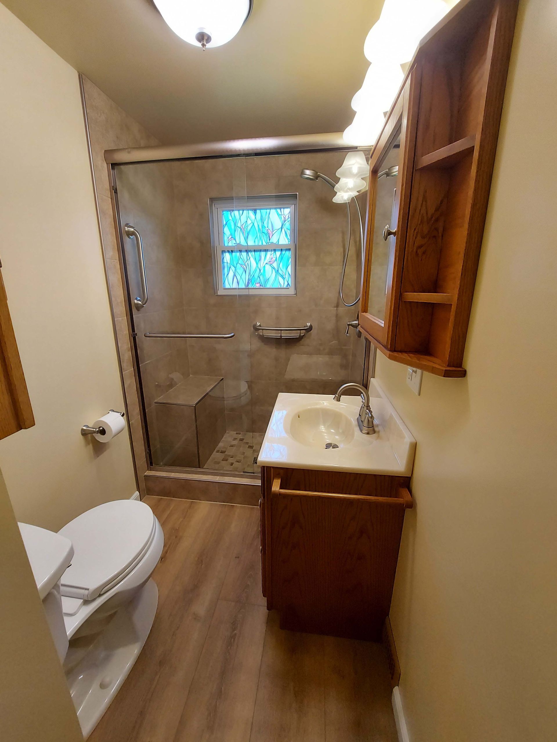 A bathroom with a toilet , sink and shower.