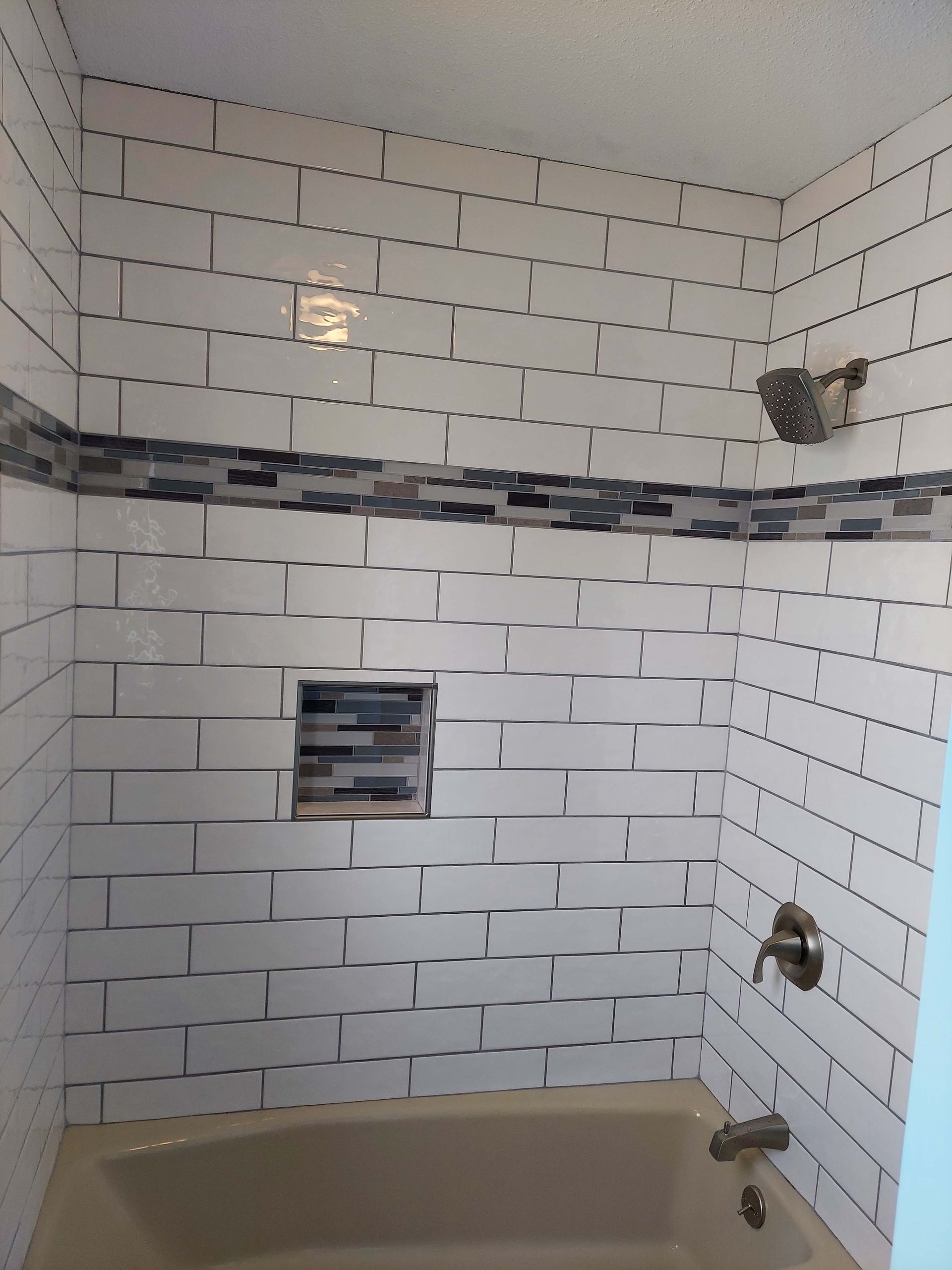 A bathroom with white brick walls and a bathtub