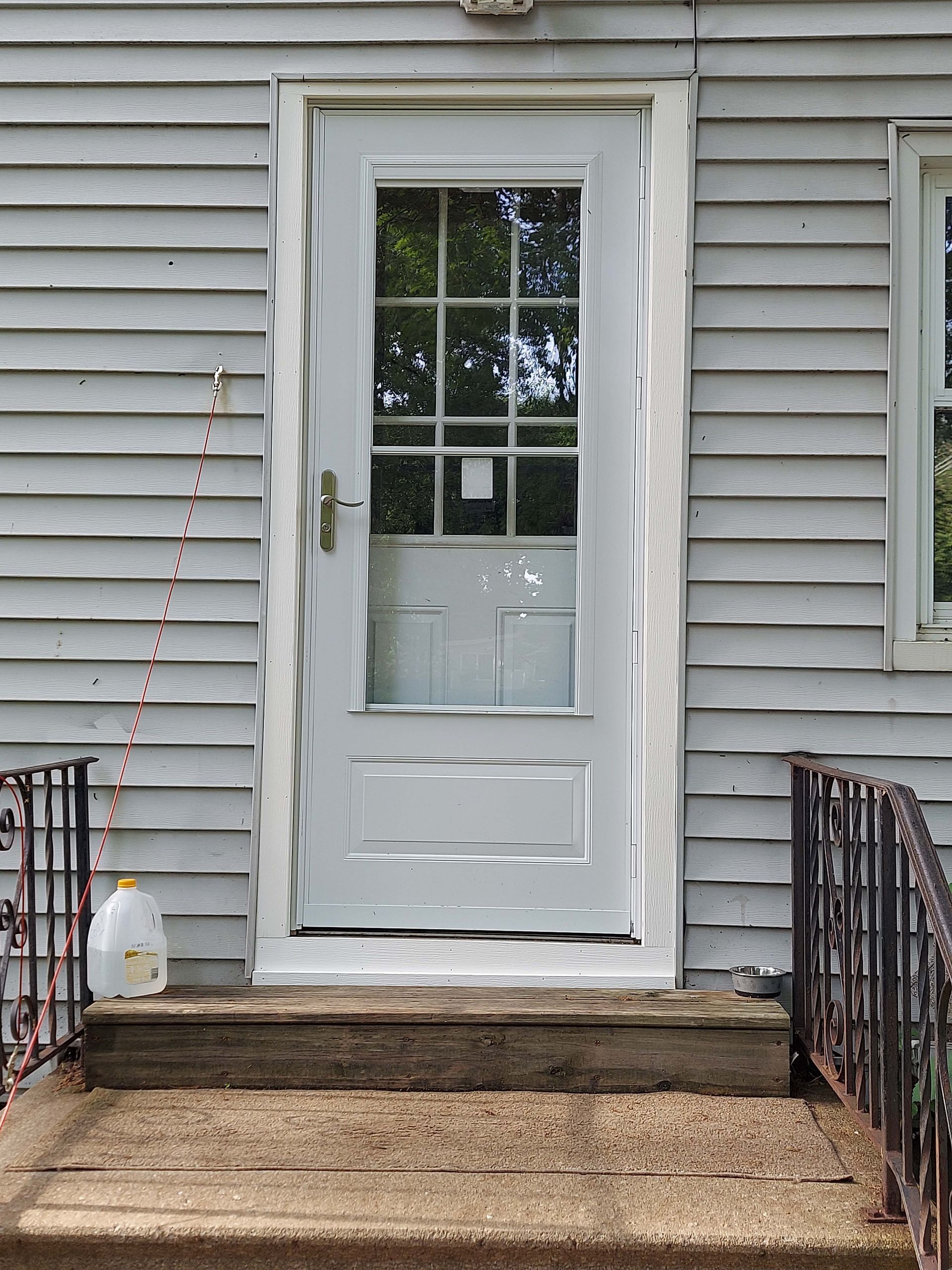 The front door of a house with a milk carton on the steps