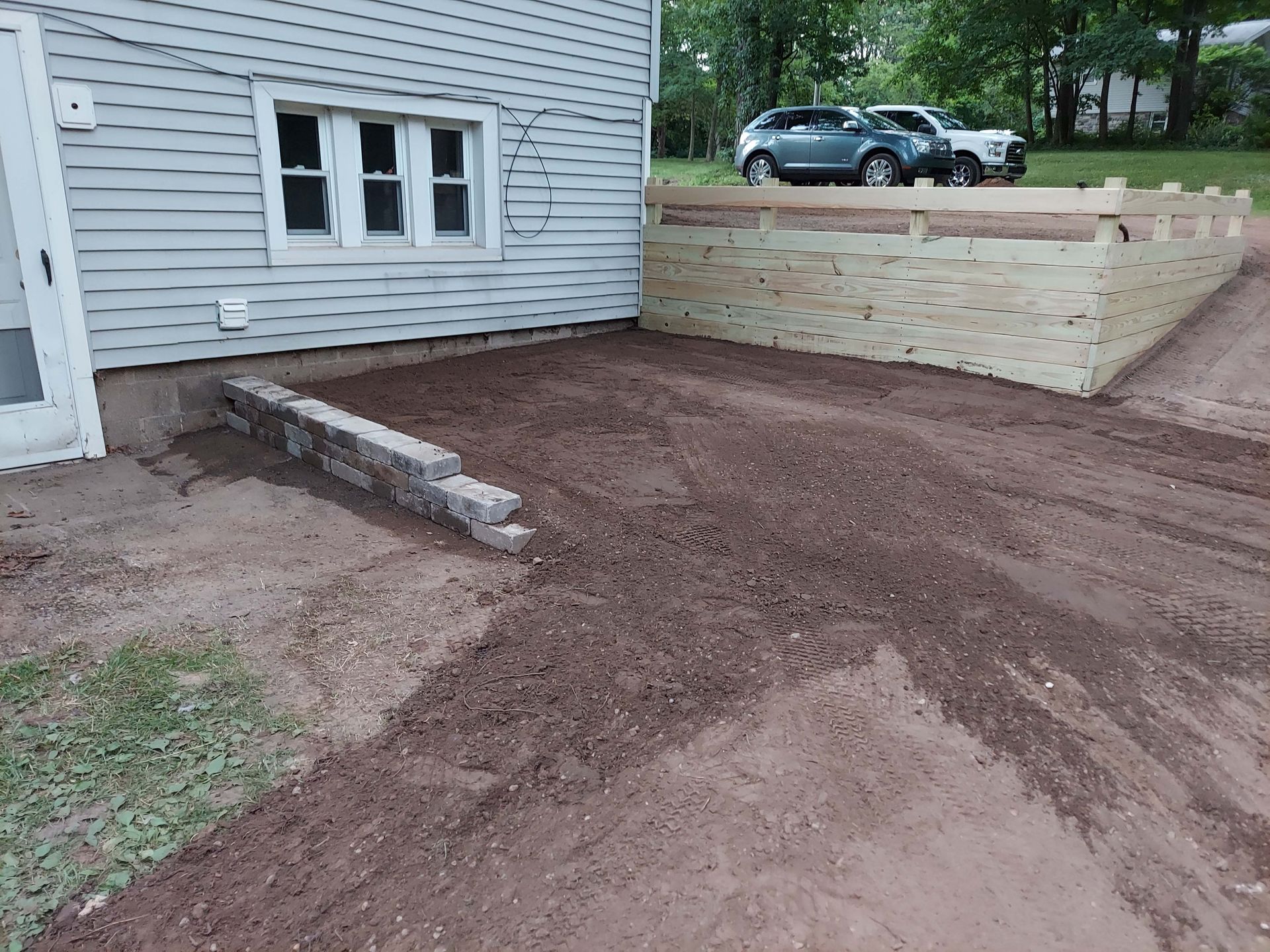 A wooden fence is being built in front of a house.