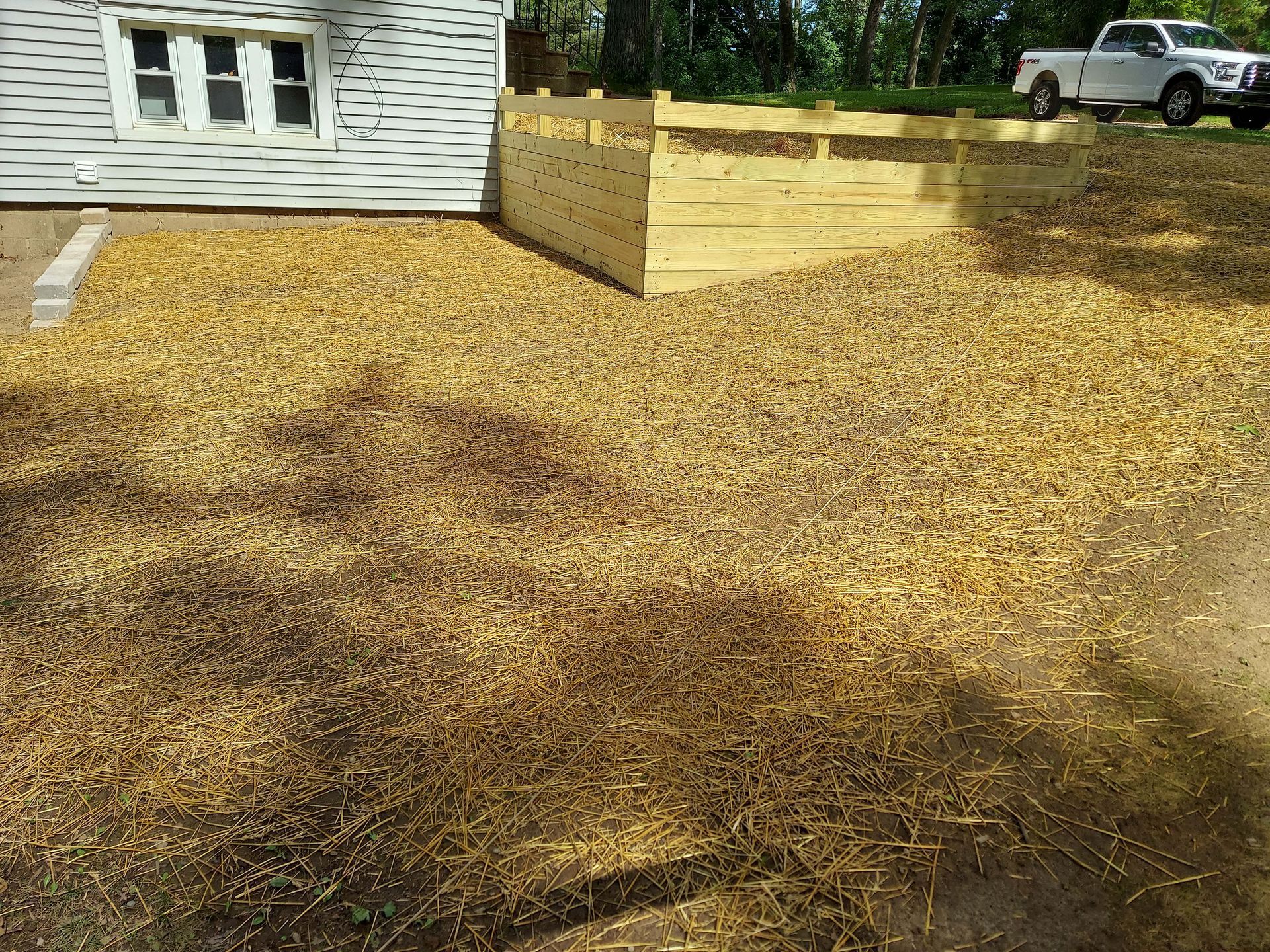 A white truck is parked in a driveway next to a house.