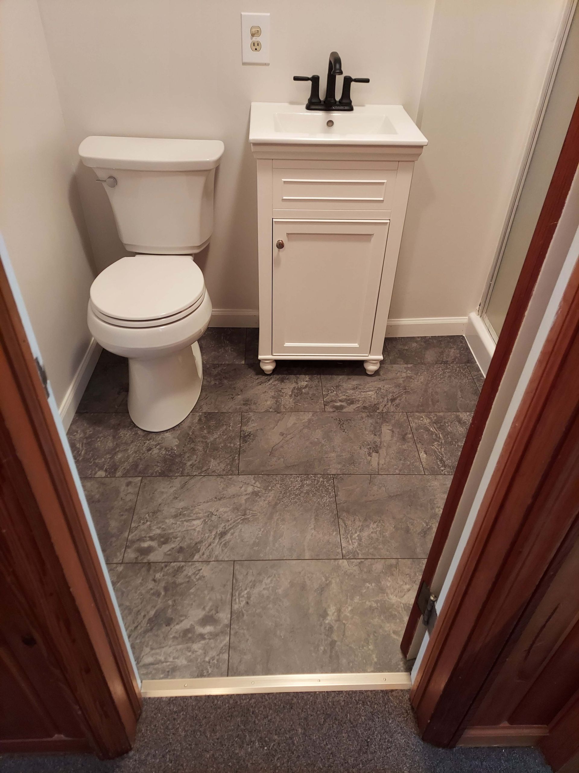 A bathroom with a toilet , sink , and walk in shower.