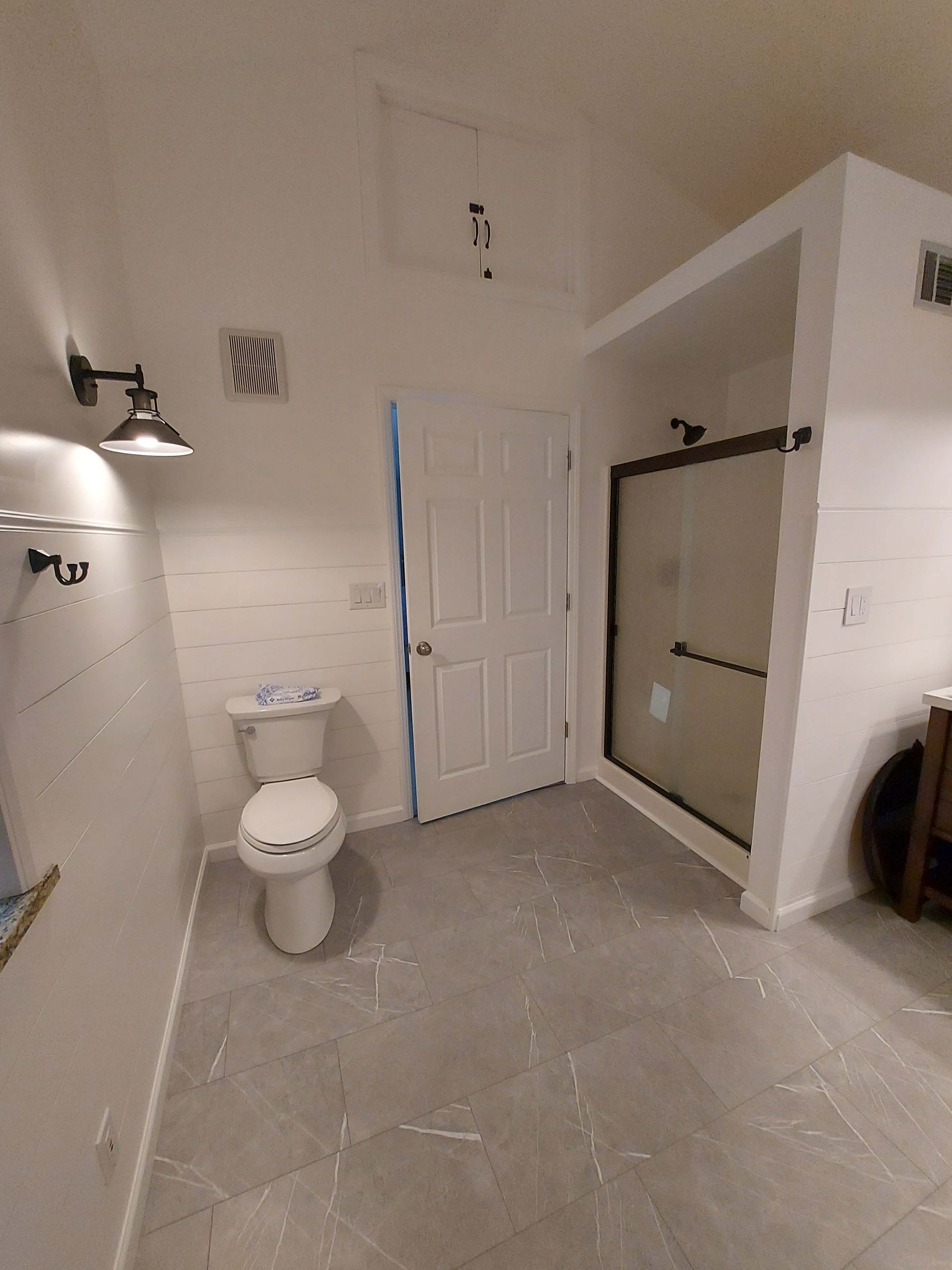 A bathroom with a toilet and a shower stall