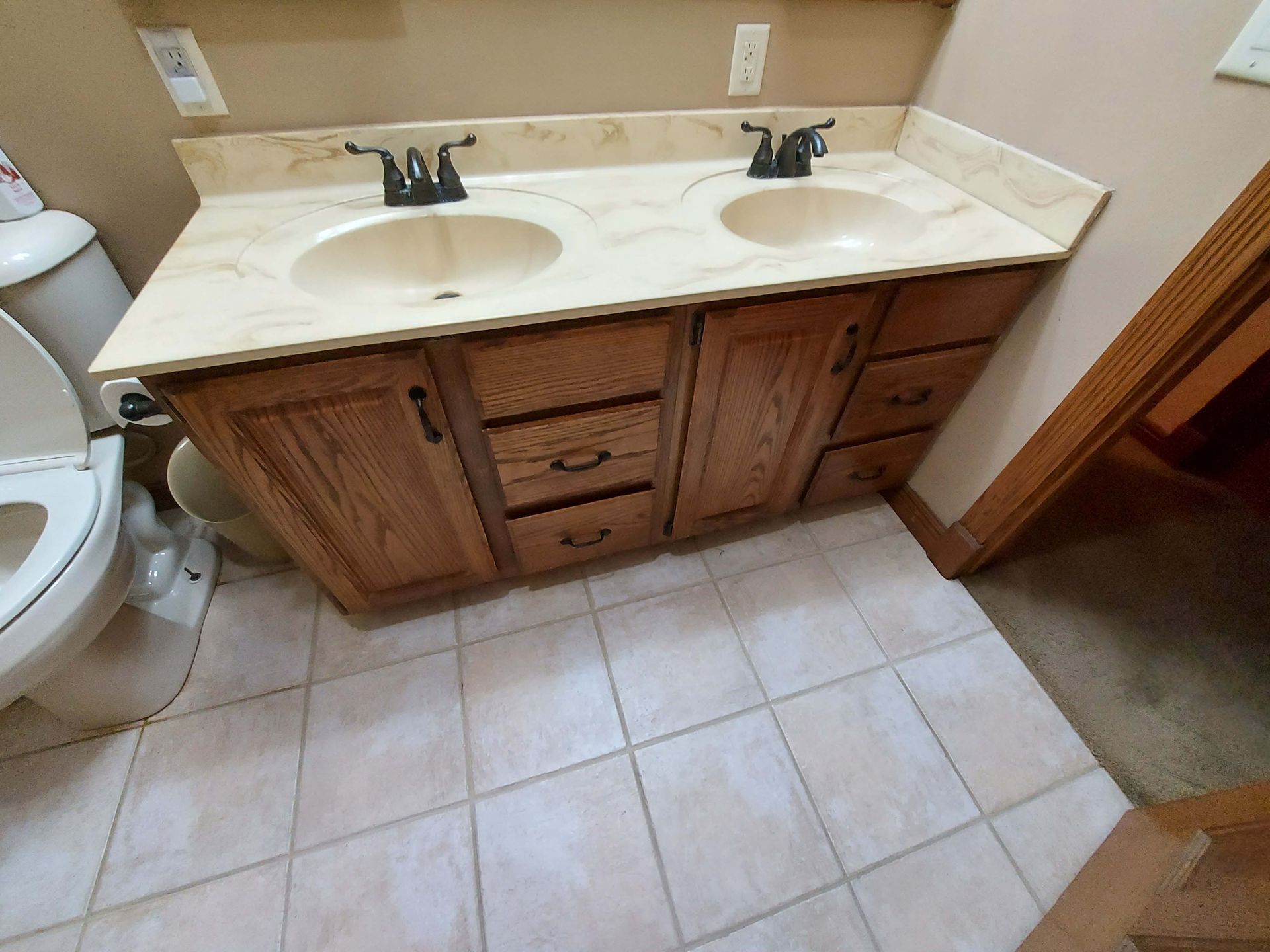 A bathroom with two sinks and a toilet