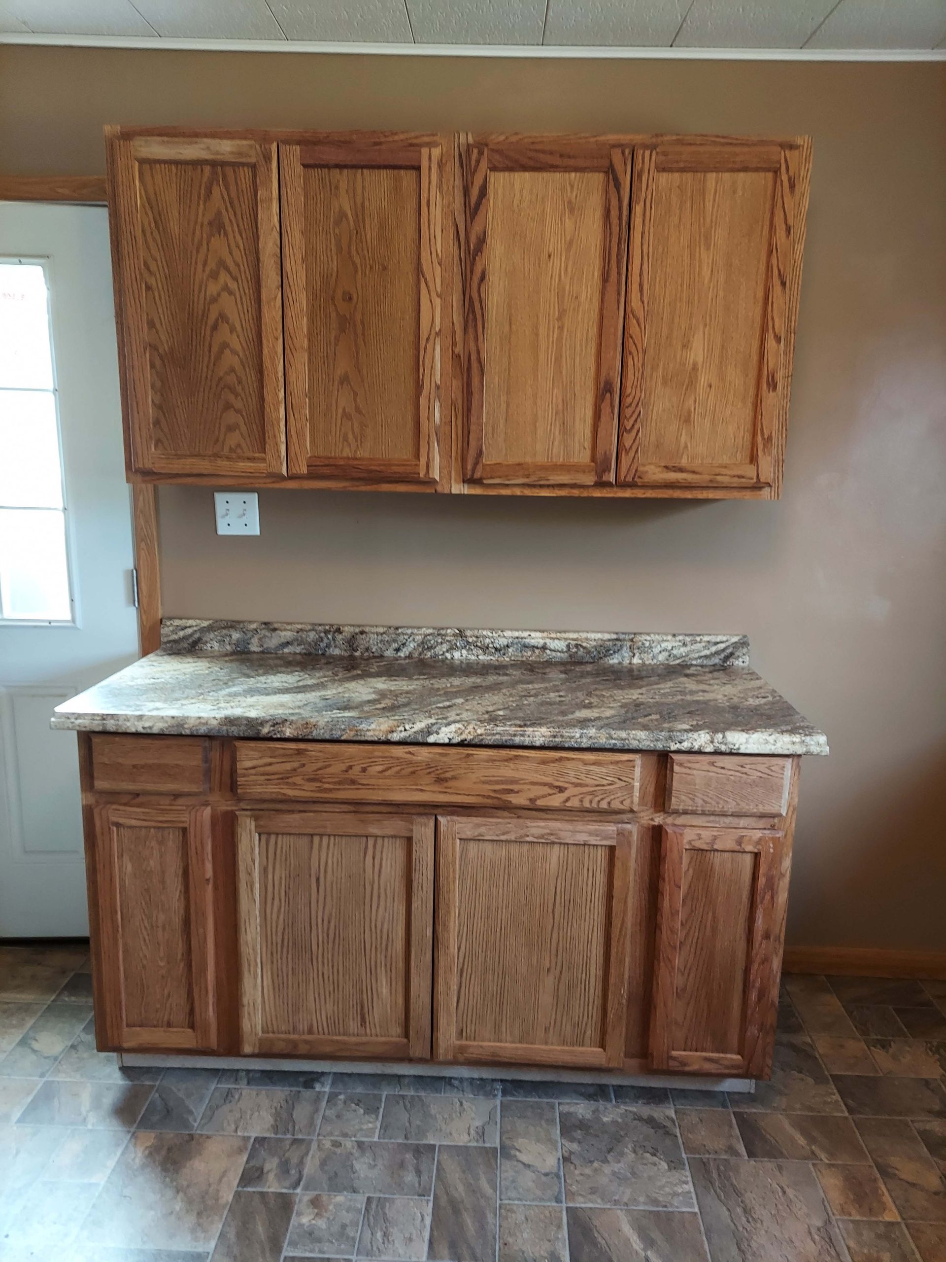 A kitchen with wooden cabinets and a granite counter top.