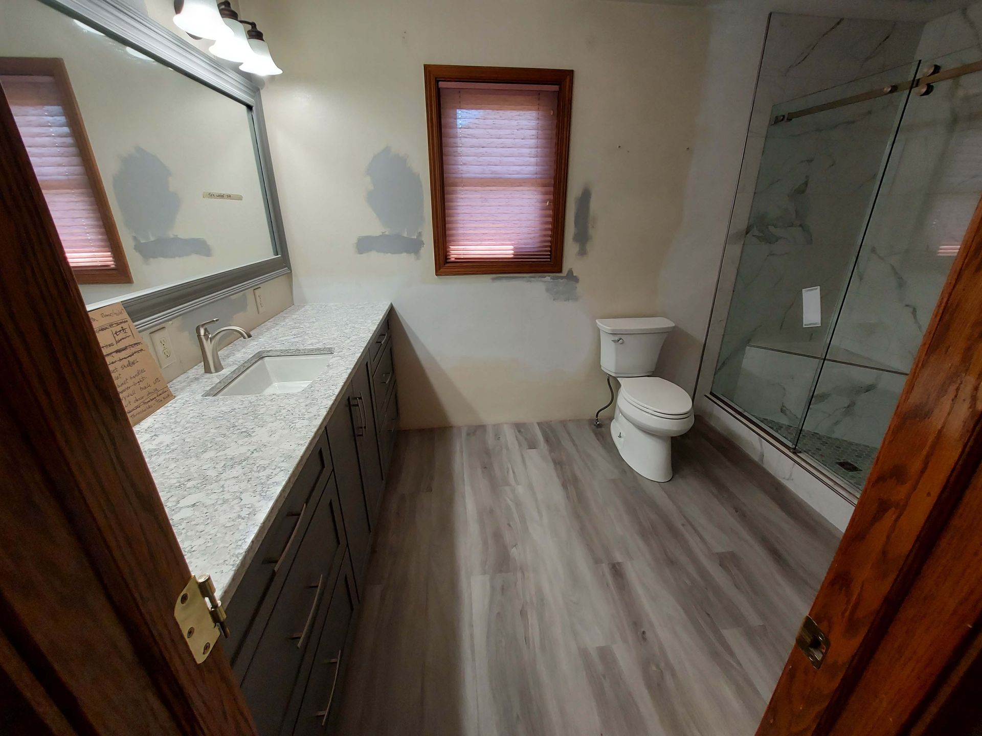 A bathroom with a toilet , sink and shower.
