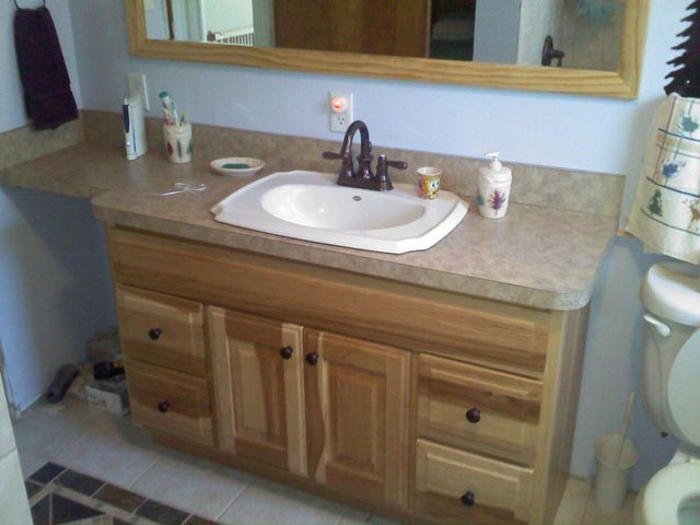 A bathroom with a sink a toilet and a mirror