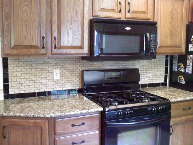A kitchen with wooden cabinets and a black stove and microwave