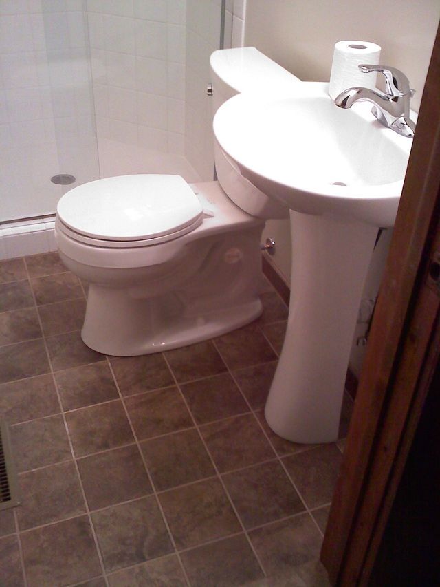 A bathroom with a toilet a sink and a shower