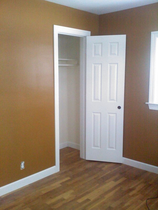 A bedroom with brown walls and a white door