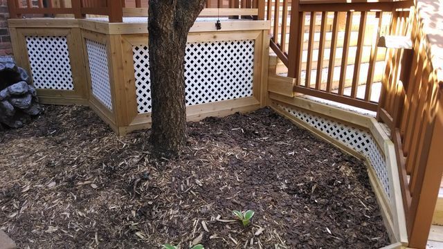 A wooden deck with a tree in the middle of it