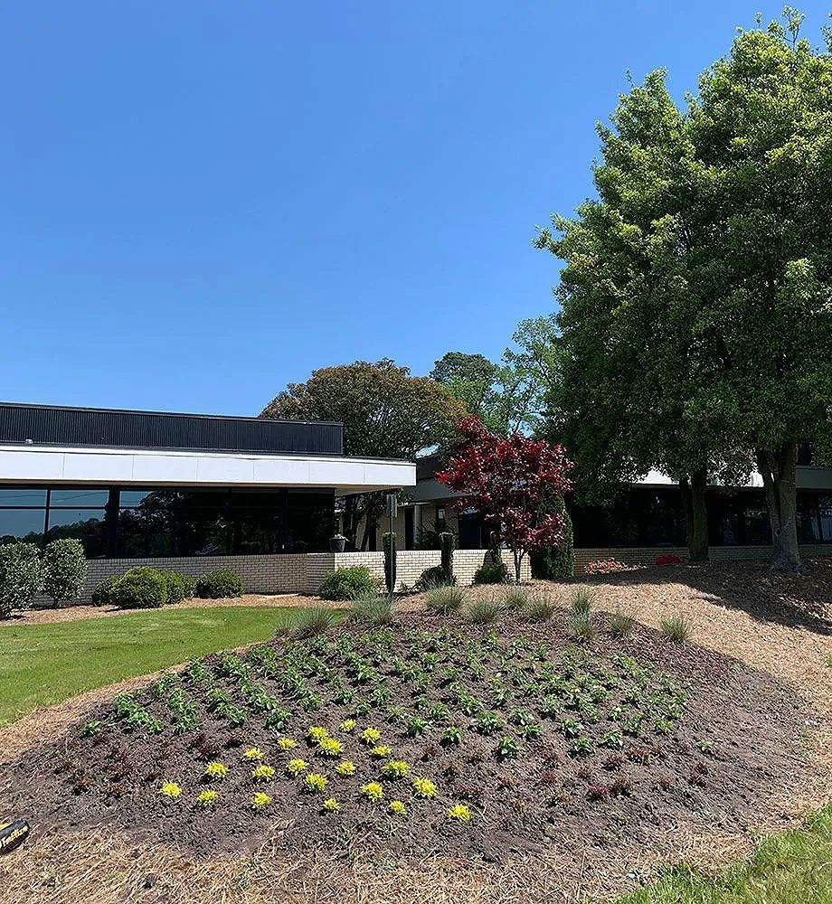 A large building with a lot of flowers in front of it.