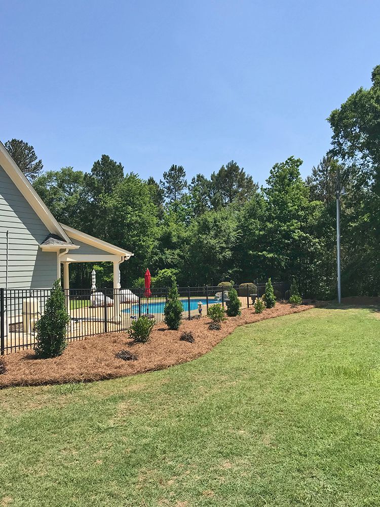 A house with a fence around it and a pool in the backyard.