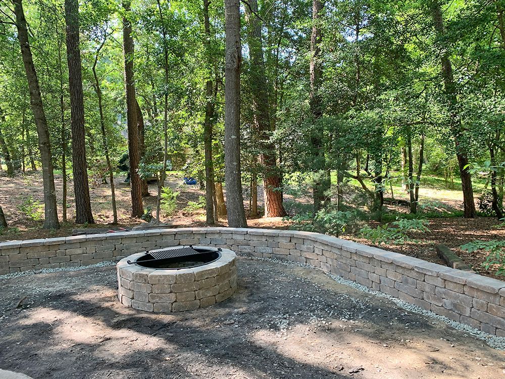 There is a fire pit in the middle of the woods.