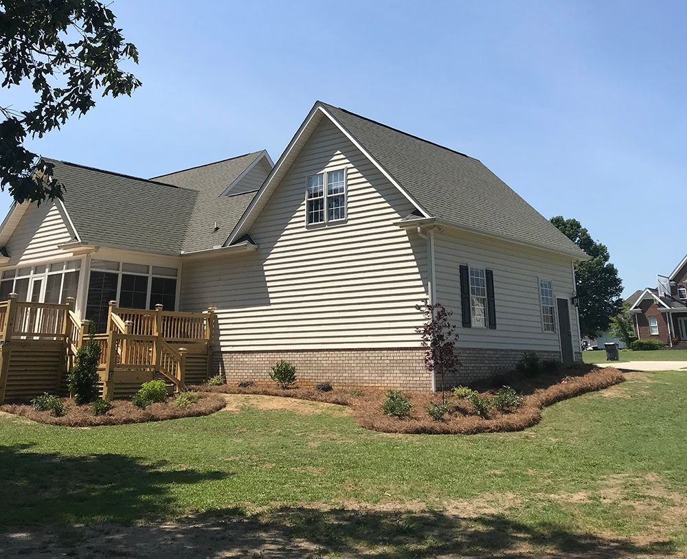 A white house with a green roof and black shutters