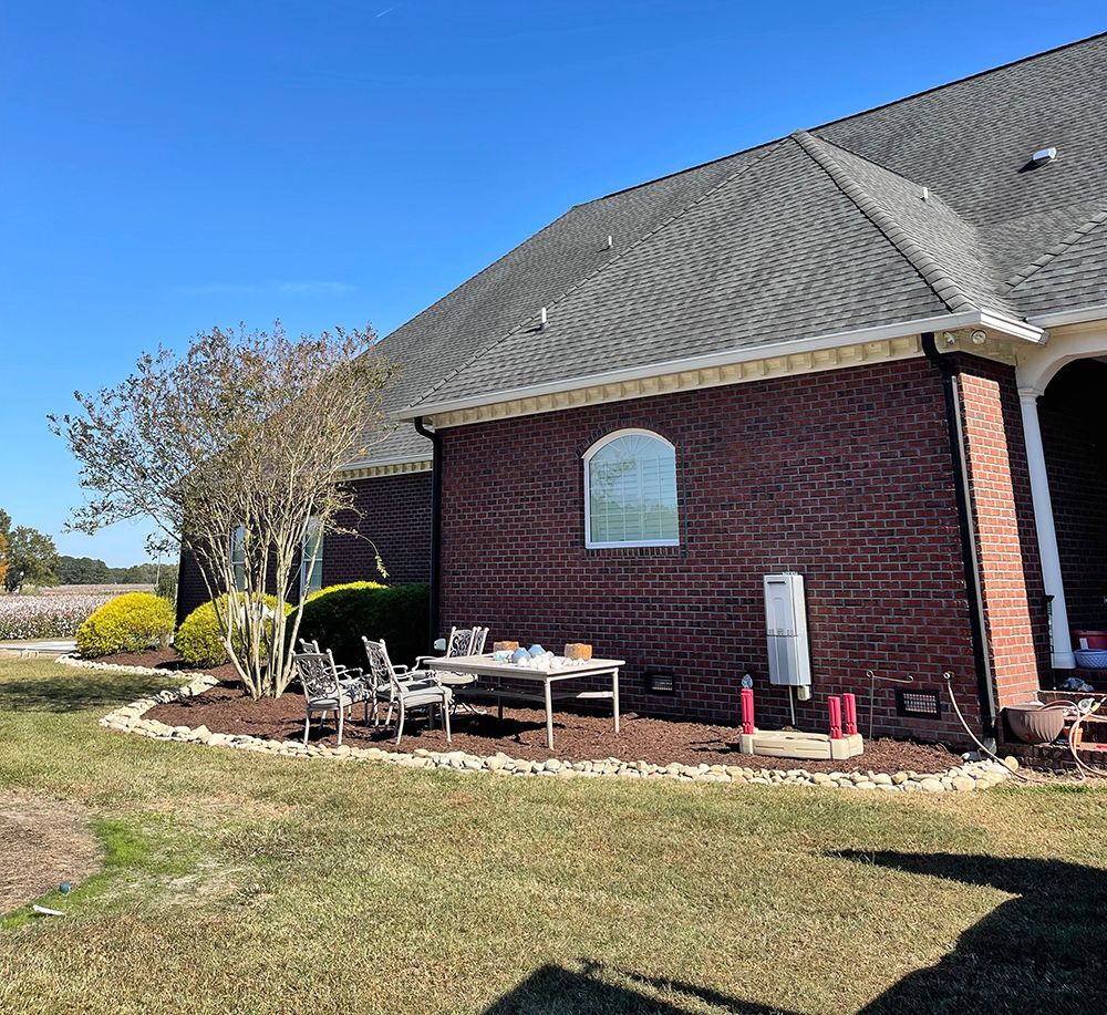A brick house with a table and chairs in front of it.