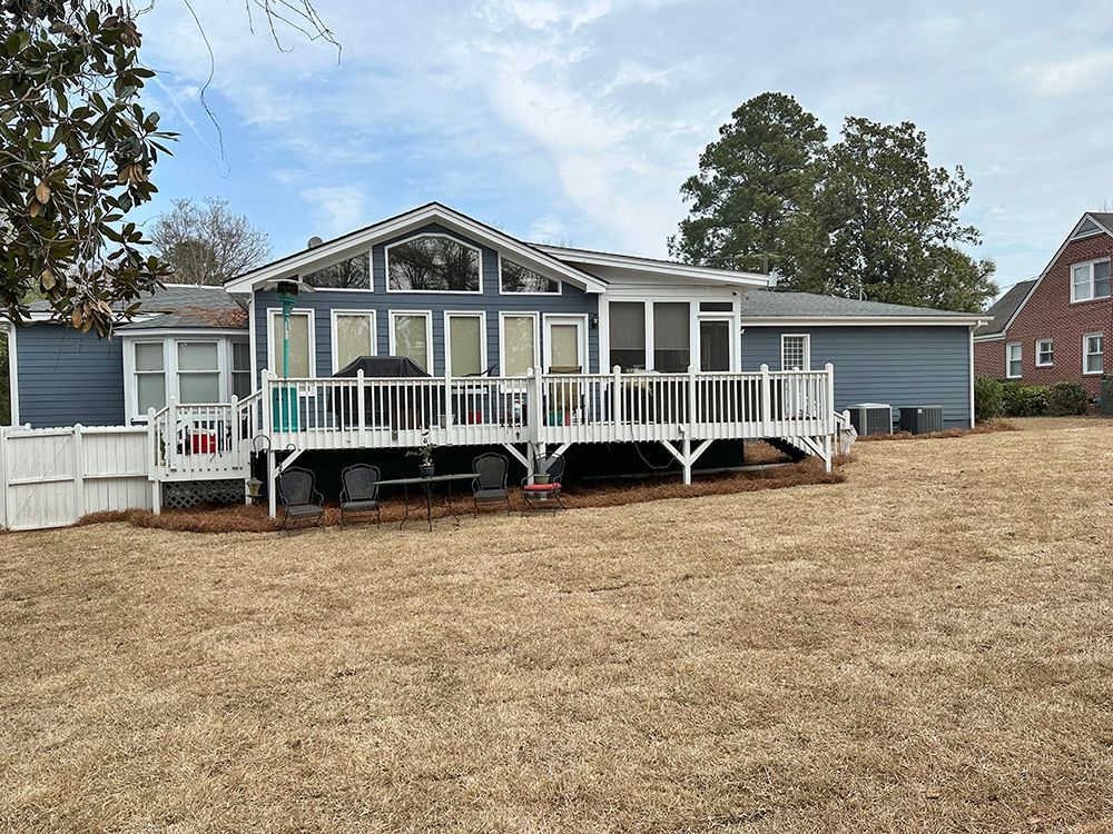 A mobile home with a large deck in the backyard.