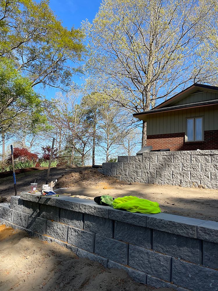 A brick wall is being built in front of a house.