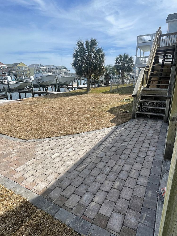 A brick walkway leading to a dock with stairs leading up to it.