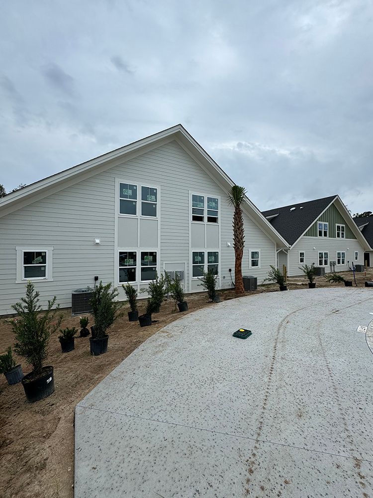 A large white house with a lot of windows and potted plants in front of it.