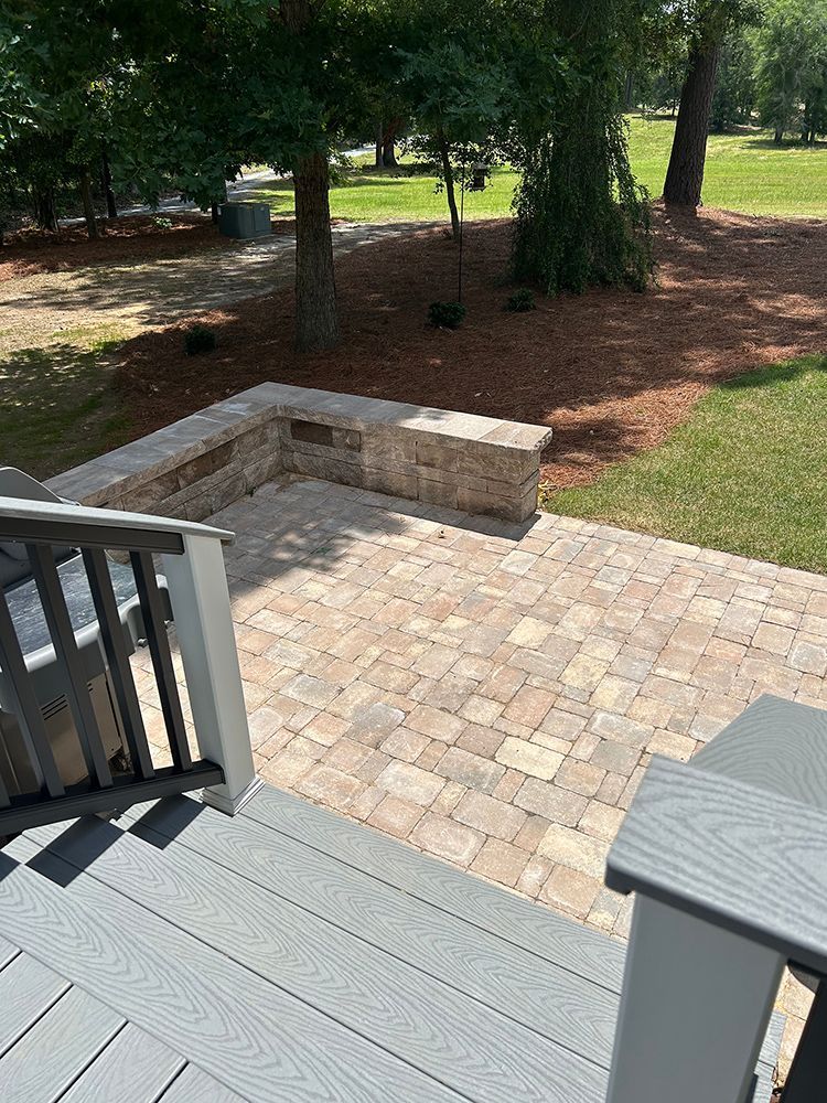 A patio with a bench and stairs leading up to it.