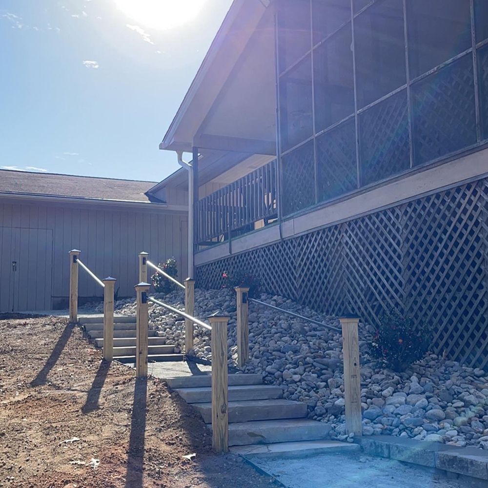A house with stairs leading up to it and a screened in porch.