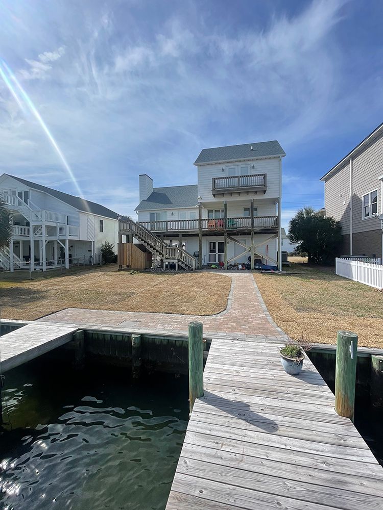 A large white house with a dock in front of it.