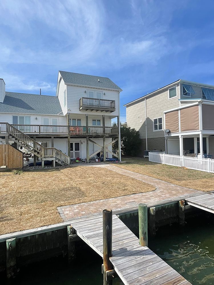 A large white house with a dock in front of it.