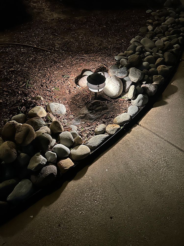 A light is shining on a rocky area at night.