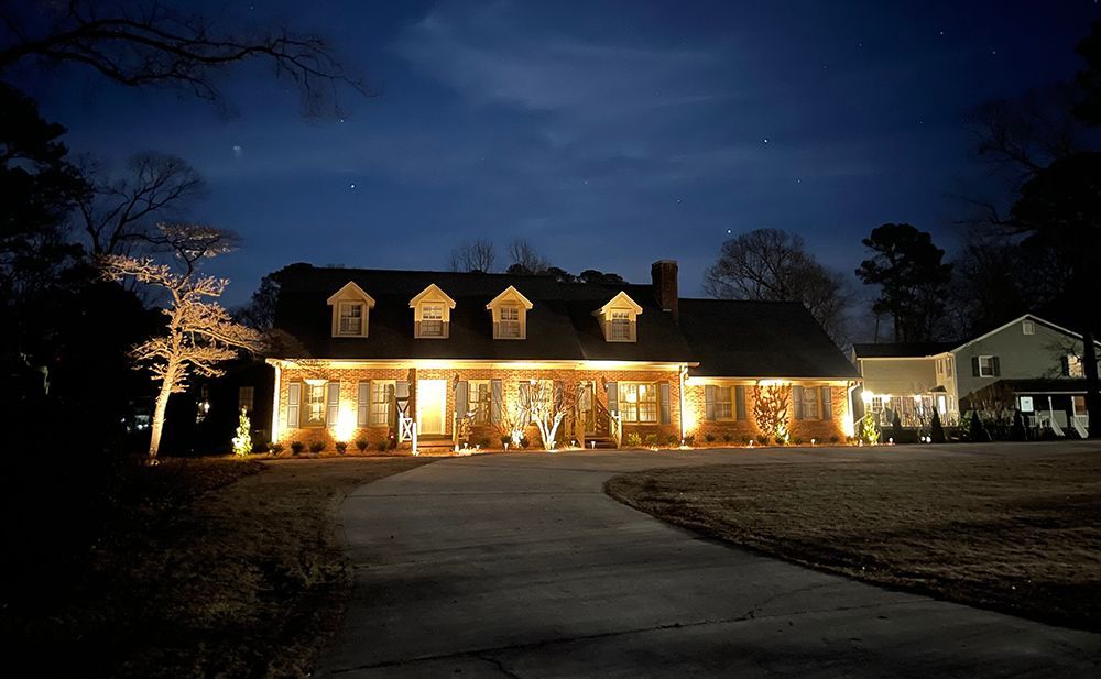 A large house is lit up at night with christmas lights