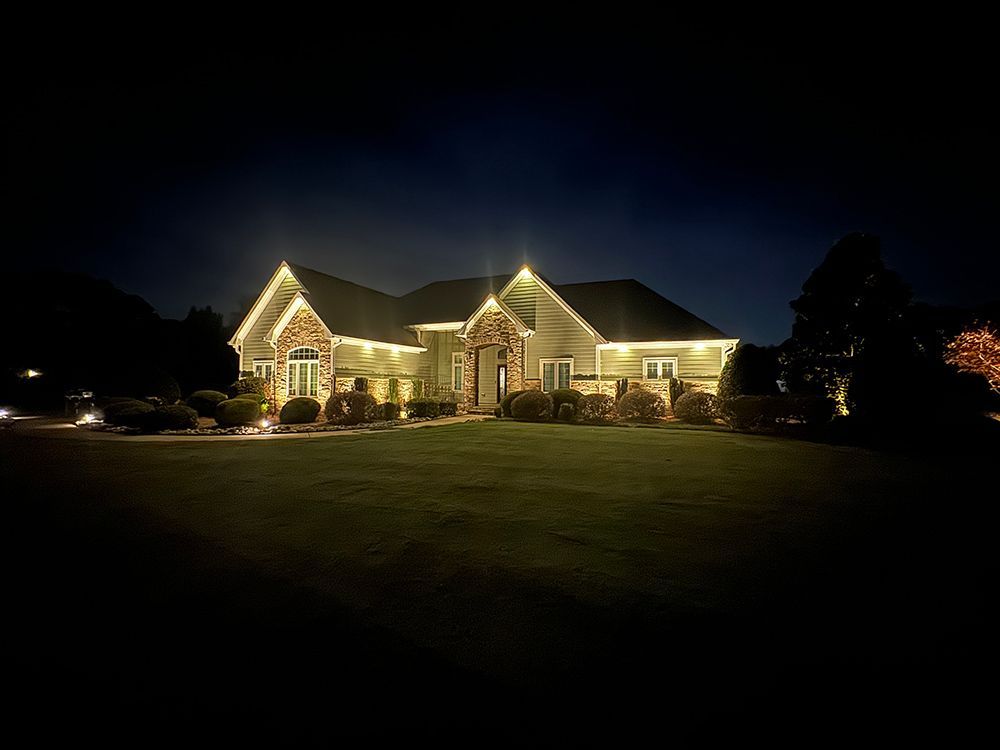 A large house is lit up at night with lots of lights.