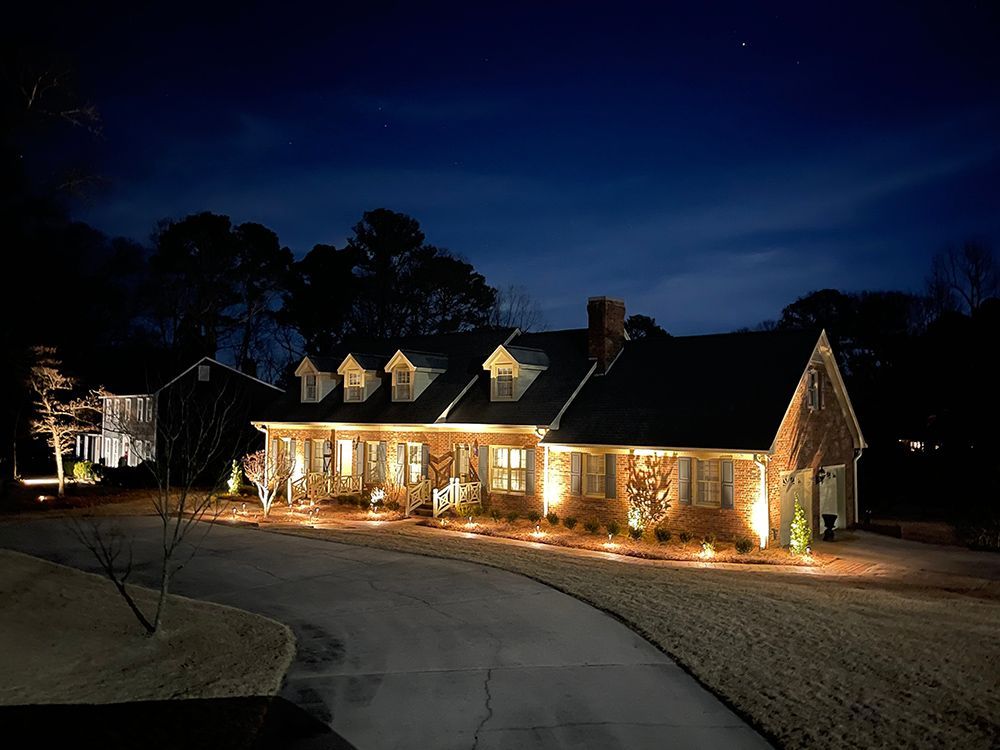 A large brick house is lit up at night